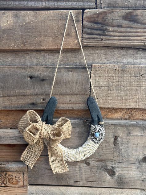 Hand decorated horseshoe. Made with white gold twine, burlap bow, and a western turquoise oval concho. Twine tied on to hang up. Personalized designs available.