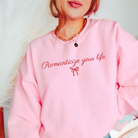 Get ready to be OBSESSED with your new Romanticize Your Life sweatshirt. It's the cutest and most trendy way to emit all those coquette vibes! This is the perfect romantic crewneck! Great as a gift! * C O L O R * I N F O* ✺ This design is printed in red on Light Pink, White, Ash, and Sand ✺This design is printed in pink on Heliconia * Q U I C K * F A C T S * ✺ 50% Cotton, 50% Polyester ✺ Wash and dry normally inside out (on cool for best results) * S I Z I N G * ✺Gildan 18000 ✺ Sizing is unisex so runs like men's, though not overly large ✺ Most women find their typical size works best, since they are meant to fit a touch loose ✺ See size guide in photos for more info * S H I P P I N G * T I M E S * ✺ Our items are individually made with love for each of our buyers. Because of this, our pro Girly Tshirt, Romantic Sweater, Coquette Sweatshirt, Coquette Clothes, Romanticize Your Life, Coquette Vibes, Coquette Shirt, Romantic Life, Cute Jumpers