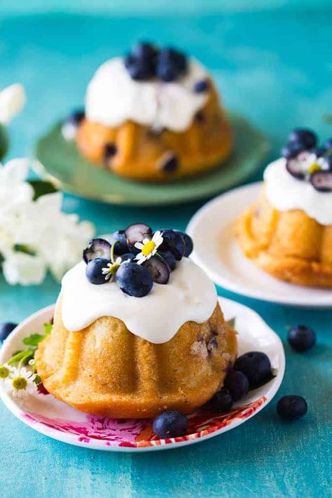 closeup of mini blueberry bundt cakes on a white platter in front of two other cakes Blueberry Cakes, Blueberry Mousse, Moist Blueberry Cake, Healthy Blueberry Cake, Speciality Cakes, Blueberry Cake Mix, Lemon Blueberry Bundt Cake, Blueberry Bundt, Blueberry Bundt Cake