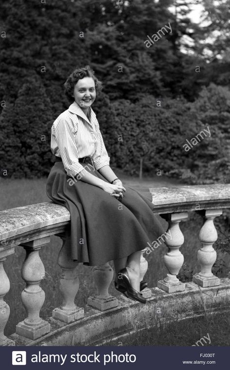 Download this stock image: Female student sitting on sturdy wall - fj030t from Alamy's library of millions of high resolution stock photos, illustrations and vectors. Sitting With Skirt Reference, Long Skirt Sitting Pose, Sitting In Skirt Reference, Skirt Sitting Down Reference, Carousel Skirt, Dress Sites, Figure Drawings, Big Skirts, Big Dresses