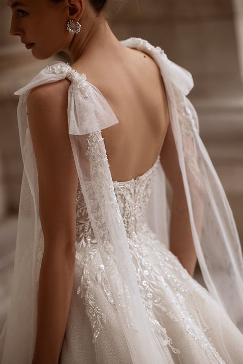 This sleeveless wedding dress features giant sheer fabric bows that rest gracefully on the shoulders. The V-neck bodice is adorned with beautiful floral lace patterns that flow over the waist and down the hips, creating a romantic and intricate design. The glistening chiffon skirt, layered beautifully, flows into a lovely train, adding a sense of grace and sophistication to the overall ensemble. This gown is the perfect choice for a bride seeking a contemporary yet timeless look for her special day. Petite Wedding Dress, Bow Wedding Dress, Pretty Wedding Dresses, Wedding Dresses With Straps, A Line Wedding Dress, Fabric Bows, Wedding Dresses Romantic, Tulle Wedding Dress, Chiffon Skirt