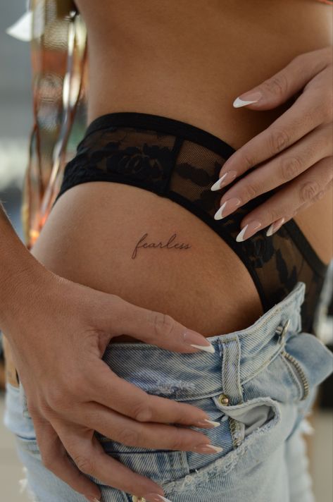 Feminine woman classy tattoo tiny idea hip tattoo Script Lettering Tattoo, Small Hip Tattoos Women, Dainty Tattoos For Women, Hip Tattoos For Women, Rose Tattoo On Hip, Fearless Tattoo, Courage Tattoos, Side Hip Tattoos, Empowering Tattoos