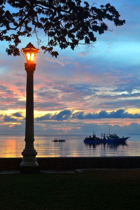 Rizal Boulevard, Dumaguete City, Philippines. Sunrise Philippines, Sun Light Lamp, Dumaguete City, Places In Philippines, Sunset Sky Clouds, Light Posts, Dumaguete, Lamp Posts, Exotic Beaches