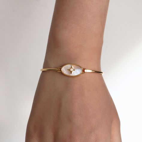 This Vintage Celestial Bracelet Bangle has a romantic design. A cute opal gemstone dotted star is adorned in a beautiful oval mother of pearl gem, the bracelet is made to celebrate romance of the space. It's a reminder of the universe and perfect for someone who loves nature-inspired accessories. Wear it on its own or with other bracelets to make your outfit shine. 18k gold plated Brass based 57mm*49mm inner diameter Armband Jewelry, Gold Vintage Bracelet, Vintage Gold Jeweled Bracelets, Gold Vintage Bracelets, Vintage Gold Opal Jewelry, Vintage Gold Bracelet With Charms, Bracelet For Women, Vintage Bracelet, Cute Bracelet