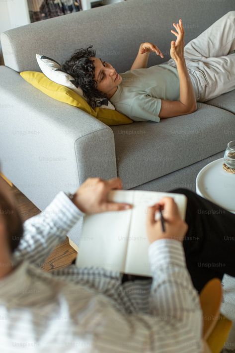 A man laying on top of a couch next to a woman photo – Therapist Image on Unsplash Laying On Couch Pose, Therapist Couch, 1111 Portal, Therapist Photoshoot, Headshots Poses, Therapy Couch, Career Manifestation, Therapist Aesthetic, Craniosacral Therapy