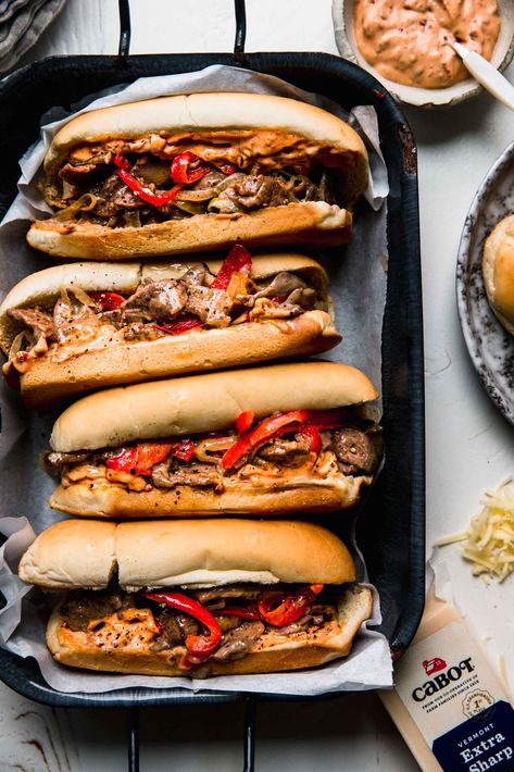 Cheesesteak Sandwiches are the ultimate comfort food. Juicy sliced sirloin, peppers, and onions piled into rolls & smothered with cheese. // recipe // philly Philly Cheesesteak Sandwiches, Steak Peppers, Cheesesteak Sandwiches, Philly Cheesesteaks, Chipotle Mayo, Cheese Steak Sandwich, Sliced Steak, Cheese Steak, Homemade Meatballs