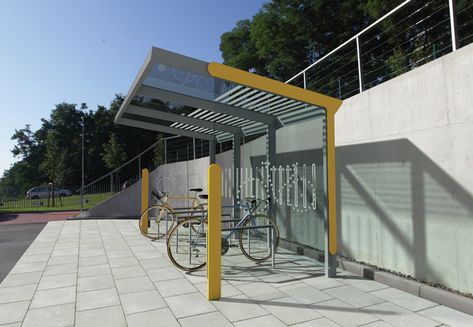 AUREO VELO by mmcité. Design is based on the aureo bus shelter range offering two roof shape options – flat and arched. Modular structure has deeper roof protecting bicycles parked underneath and increased height enables two-tier bicycle parking. Walls are made of tempered glass with safety serigraphy. The shelter can be optionally supplied with two-tier bicycle rack system. Bike Parking Design, Bicycle Parking Design, Bike Shelter, Urban Furniture Design, Bus Shelters, Roof Shapes, Public Space Design, Modular Structure, Bicycle Parking