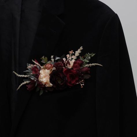 Elegant and timeless, our pocket boutonniere in burgundy and blush pink combines rich tones with soft accents for a perfect romantic touch. Ideal for grooms and groomsmen who want to add a refined, yet bold statement to their wedding attire. #burgundywedding #burgundyflowers #blushpinkwedding #pocketboutonniere #burgundyboutonniere #weddingboutonniere #PromAccessories #weddindflorist #weddingvendor Dark And Moody Boutonniere, Burgundy Pocket Boutonniere, Moody Boutonniere, Groom Pocket Flowers, Mens Boutineers Wedding, Groomsmen Burgundy, Grooms And Groomsmen, Pocket Boutonniere, Pocket Flowers