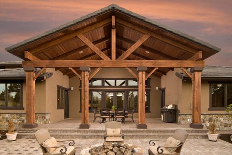 Even the rear of this home includes a grand architectural statement. Tall wooden beams lead up to a massive arched patio cover. The beautiful stone patio continues into a fire pit area with four elegant armchairs. Porch Cover, Cedar Porch, Covered Patio Design, Building A Porch, Patio Roof, Wood Patio, House With Porch, Pergola Plans, Pergola Patio