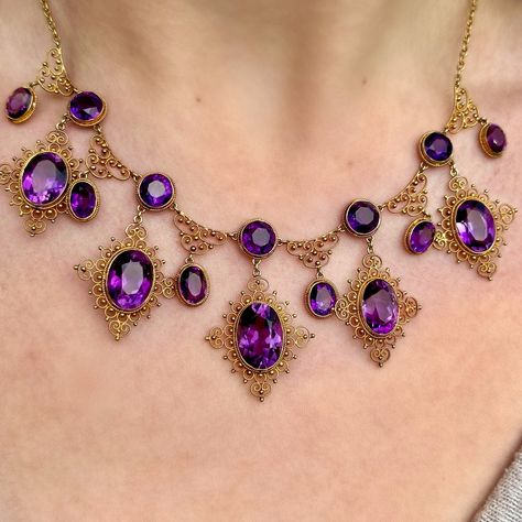 Happy National Antiques Day! Behold, the amethyst necklace of dreams!💜✨ A majestic antique Victorian necklace featuring a fabulous gallery consisting of eleven droppers and sixteen deep purple amethysts that range from approx. 0.80ct to 6ct (approx. 32ct total). Each stone is bezel set with a rope edge and surrounded by beautiful, scrolling cannetille metalwork all fashioned in 18ct gold. The piece dates to the late 19th Century and is in excellent condition. A glamorous and regal statement... Magnificent Century Jewelry, Amethyst Jewelry Necklace, Victorian Jewelry Necklace, Ornate Necklace, Antique Jewelry Victorian, British Crown Jewels, Baroque Jewelry, Colourful Jewellery, Victorian Jewellery