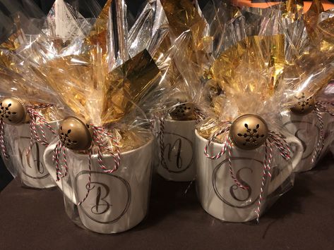 Take a pretty monogram mug from bed bath and beyond, inside wrap a Starbucks coffee gift card and Hershey chocolate kisses on a gold tissue paper. Wrap all around with clear cellophane paper using ribbon to tie and adding a jingle bell for final touch. #starbucks #bedbathandbeyond #hersheyskisses Coffee Mug Gift Wrapping Ideas, Clear Gift Wrapping Ideas, Christmas Coffee Gifts Ideas, Cellophane Gift Wrapping Ideas, Wrap Mug Gift, Christmas Return Gifts, How To Gift Wrap A Mug, Gift Mugs Ideas Filled, Mug Wrapping Ideas Diy Gifts