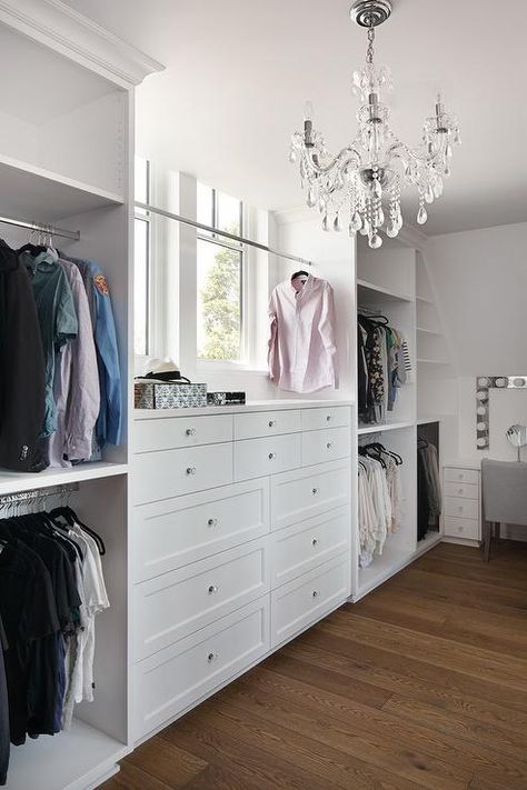 Flanked by stacked clothing rails, this walk in closet is equipped with a white built-in dresser accented with glass knobs and positioned beneath a tension rod clothing rail mounted in front of a window lit by a crystal chandelier. Walking Closet Ideas, Master Closet Ideas, Alex Drawers, Organization Vanity, Master Closet Design, Organization Shelves, Dresser In Closet, Built In Dresser, Table Makeup