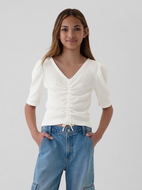 Soft cotton-blend ribbed knit shirt.  V-neck.  Elbow puff sleeves.  Ruching at front.  Straight, easy fit.  Hits at the hip. Gap Tops For Spring, Trendy Gap Tops For Spring, Spring Stretch Tops By Gap, Casual Ribbed Puff Sleeve Top For Spring, Casual Stretch Cotton Puff Sleeve Top, Casual V-neck Puff Sleeve Top For Spring, Casual Ribbed Puff Sleeve Tops, Fitted White Gap Top, Spring Casual V-neck Puff Sleeve Top