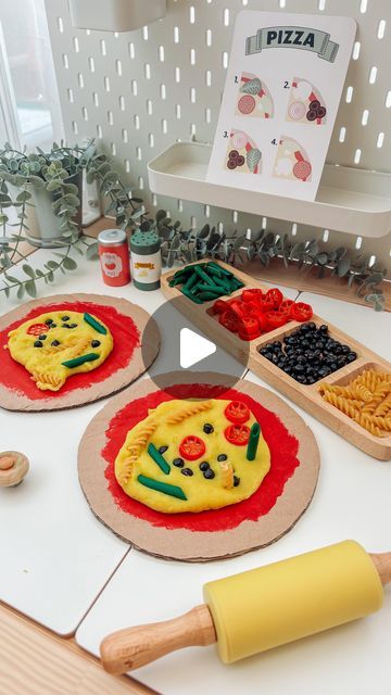 Engaging Elodie on Instagram: "Elodie loved our pizza mud kitchen a few weeks ago so this week I reused the ‘pizza bases’ for an indoors activity! 🍕  The cheese is home made playdough (message me if you want the recipe)! And all the toppings are pasta/chickpeas covered in paint.   A lovely activity for developing fine motors skills and creative/imaginary play. 🍕💛  #playdoughplayactivities #sensoryplay #messyplay #toddleractivities #reelsdaily #finemotorskills #prewritingskills #creativeplay #learningthroughplay #toddlerdevelopment #playbasedlearning #homeeducation" Cooking Experience Preschool, Playdough Ideas For Kids, Pizza Activities For Kids, Pizza Activities For Preschool, Pizza Playdough, Home Made Playdough, Gf Dough, Playdough Activities Preschool, Pasta Chickpeas