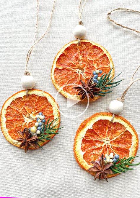 + +"These ornaments are made with a dehydrated orange slice...al star anise...d artificial evergreen twig and blue berries. It is strung on rustic jute twine with a wo..