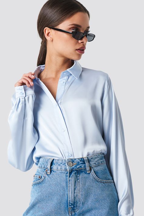 The Long Sleeve Satin Shirt by NA-KD Classic features a collared neckline, buttons down the front, two buttons at each cuff, a wide fit, and smooth silk material. Blue Shirt Outfit, Satin Shirt Outfit, Timeless Wardrobe Essentials, Stylish Knitwear, Capsule Closet, Satin Blouses, Satin Shirt, Satin Blouse, Silk Material