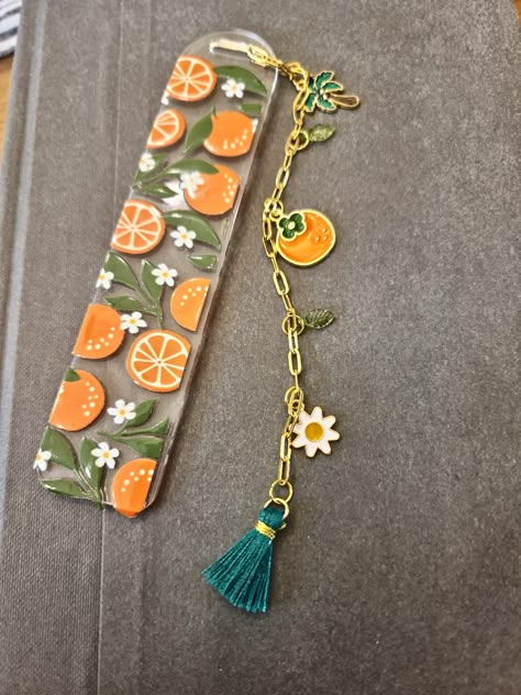 Cute acrylic bookmark with oranges decal. Gold chain with assorted funky charms makes up the tassel. Acrylic Bookmarks Diy, How To Make Bookmarks Diy, Orange Bookmark, Bookmark Jewelry, Acrylic Bookmark Ideas, Bookmarks Acrylic, Polymer Clay Bookmark, Acrylic Bookmarks, Girls Night Crafts