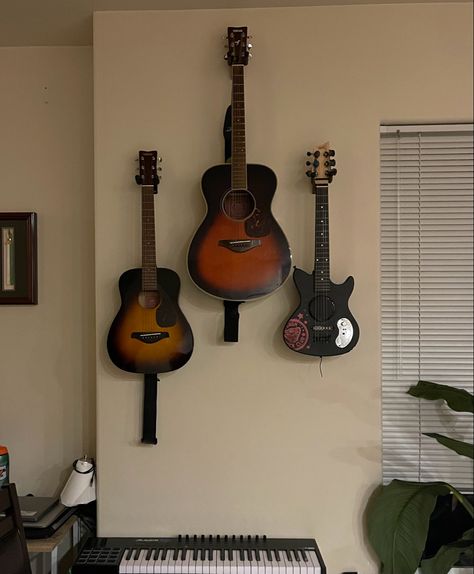 Guitars neatly organized up on the wall to get them off the floor, clearing some floor space and simultaneously adding an artsy touch on the wall. Guitars On Wall, Hanging Guitars, Realistic House, Guitar Wall Hanger, Guitar Room, Navy Walls, Guitar Wall, Guitar Collection, Walls Room