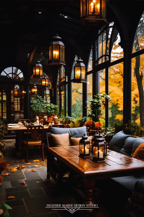 Experience the rustic charm of this farmhouse-inspired enclosed porch with large beautiful windows and a moody autumn aesthetic ✨🪴 The charming wood furniture and farmhouse lighting create a cozy haven, while the rustic potted plants breathe life into this enchanting space 🏡🌿#RusticFarmhousePorch #CharmingInteriors #InteriorDesignInspo #NaturalBeauty #CozyEscape #HomeDecorDreams #FarmhouseCharm #CountrysideLiving #WoodenFurniture #RusticElegance Dark And Moody Outdoor Space, Autumn Cafe Aesthetic, Moody Autumn Aesthetic, Moody Porch, Eclectic Front Porch, Moody Patio, Moody Sunroom, Rustic Home Aesthetic, Moody Eclectic Decor