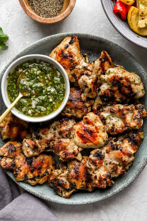 Charred, juicy and so delicious, these grilled Chimichurri Chicken Thighs make for the perfect dinner! Boneless chicken thighs are marinated in chimichurri, grilled up and served with another spoonful of that bright green sauce. This recipe is a summertime-must that is gluten-free, paleo and Whole30-friendly. Chimichurri Chicken Thighs, Charred Chicken, Grilled Whole Chicken, Chimichurri Chicken, Chimichurri Recipe, Grilled Chicken Thighs, Perfect Dinner, Green Sauce, Boneless Chicken Thighs