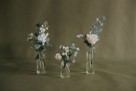 Dusty Blue Bud Vases Wedding, Blue Bud Vase Centerpiece, Blue Bud Vases Wedding, Candle Greenery Centerpiece, Blue Delphinium Centerpiece, Bud Vases Blue Flowers, White And Green Bud Vases, Blue Vase Centerpieces, Blue Floral Bud Vase