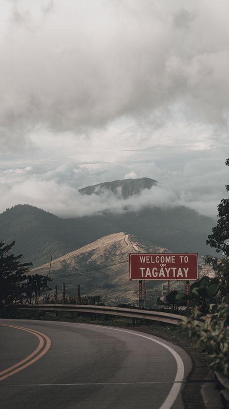 Scenic view of Tagaytay's mountains with a "Welcome to Tagaytay" sign along a road, cloudy sky, and cratered mountains in the background. Tagaytay Aesthetic, Tagaytay View, Philippines Tagaytay, Tagaytay Philippines, Philippines Destinations, Kitty Videos, Travel Mood, Mountainous Landscape, Hello Kitty Videos