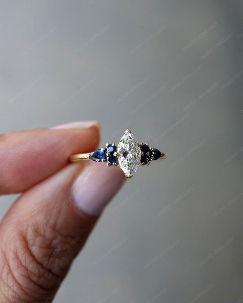 "★ RING INFORMATION ★ ------------------------------------------------------------------- ★ MAIN STONE ➺ SHAPE  :- Marquise cut Moissanite ➺ Weight :- 1.0 ct ( 10 x 5 MM )  ➺ Color :- colorless /white ➺ VVS Clarity ------------------------------------------------------------------- ★ SIDE DIAMOND  ➺ SHAPE  :-Pear And Round Sapphire   ➺ Weight :- 0.80 CT  ➺ Color :- Blue ➺ VVS Clarity  ------------------------------------------------------------------- ★ BAND  ➺ BAND WIDTH  :- 2.0 MM ➺ BAND THICK Diamond Ring With Sapphire Side Stones, Marquise Diamond And Sapphire Ring, Marquise Engagement Ring With Sapphires, Engagement Ring Sapphire Side Stones, Blue Marquise Diamond Ring, Diamond With Sapphire Side Stones, Marquise Sapphire Ring, Marquis Sapphire Ring, Sapphire Marquise Engagement Ring