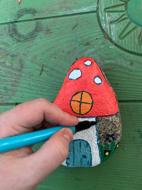 Learn how to paint a fairy house on a garden rock. This adorable fairy house will look great in your garden propped up next to a tree trunk. Add a touch of whimsy to your outdoor space with this fun painted rock craft. This painted rock craft is so easy to do and kids of all ages will have fun making them. I’m not sure what it is about painting rocks but it seems to be a universal craft that all kids love to do. Plus it’s pretty much free- all you need is rocks from the garden and a li… Fairy Rocks, Fairy Garden Cottage, Mini Pine Cones, Cat Patio, Rainy Day Crafts, Bird Houses Painted, Mushroom Fairy, Halloween Lanterns, Guest Bedroom Decor