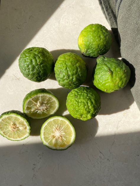 Green Kaffir Limes Laying in the Sunlight on a Travertine Table Beside a Papier-mâché Vessel Bergamot Aesthetic, Retreat Photoshoot, Pupil Dilation, Citrus Aesthetic, Lime Aesthetic, Candle Instagram, Foodie Aesthetic, Travertine Table, Fertility Foods