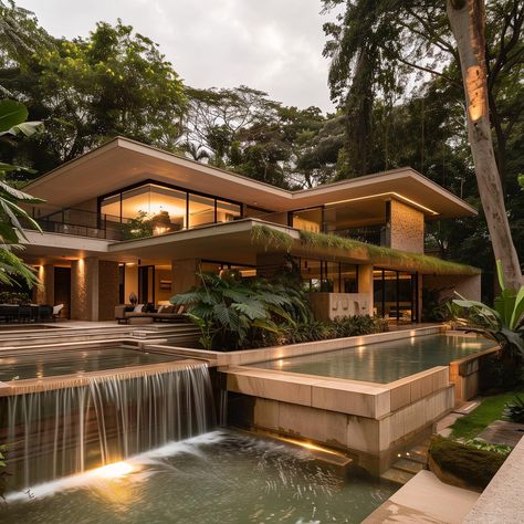 Secluded exterior of a mid-century modern mansion featuring a cascading waterfall flowing into a swimming pool, surrounded by trees. Mid Century House Architecture, Mid Century Modern Mansion, Mid Century Mansion, Midcentury Modern Mansion, Mid Century Modern Architecture, Mid Century Modern House With Pool, Modern Mansion Exterior, Mid Century Modern Mansion Floor Plans, Mid Century Modern Forest House