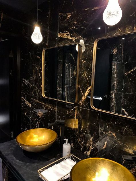 a refined powder room with black marble tiles, gold sinks, gold frame mirrors and catchy pendant lamps Restaurant Toilet Design, Restaurant Toilets, Gold Tiles Bathroom, Gold Bathroom Decor Ideas, Black And Gold Bathroom Decor, Black Marble Tile, Gold Toilet, Gold Bathroom Decor, Black And Gold Bathroom