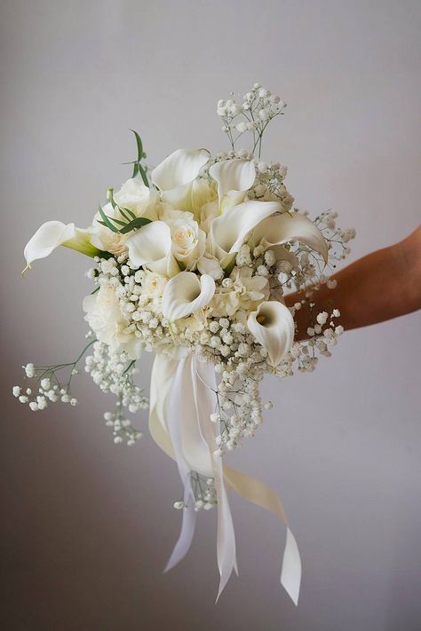 A lily bridal bouquet with calla lilies and baby’s breath. White Jasmine Bouquet, Gold And White Bouquet Wedding, Flower Bouquet Beach Wedding, Timeless Bouquet Wedding, January Bridal Bouquet, Calla Lily And Tulip Wedding Bouquet, Cala Lily Bouquets Bridesmaid, White Rose And Calla Lily Bridal Bouquet, Fall White Bouquet