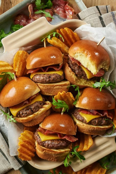 A close-up photo of mini cheeseburgers in an oven dish on a table. Cheeseburgers Recipe, Mini Burgers Recipe, Classic Cheeseburger, Streaky Bacon, Mini Cheeseburger, Slider Rolls, Rocket Leaves, Mini Hamburgers, Hot Cross Buns Recipe