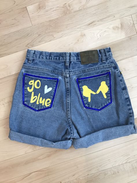 Hand painted items - see instagram if interested in purchase! denimbydesignn #DIY #umich #universityofmichigan #michigan #maize #blue #harbaugh #shorts #cutoffs #painted #denim #jean #jeanjacket #jeanshorts #jacket #shorts College Tailgate Outfit, Football Tailgate Outfit, College Gameday Outfits, College Tailgating, Painted Shorts, Diy Denim Jacket, Painted Clothes Diy, Senior Overalls, Diy Jeans