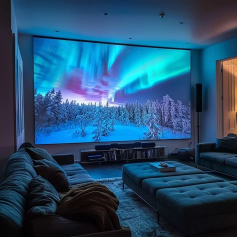 Cozy home theater room with northern lights projection screen, snow-covered forest, ambient blue lighting, and leather sofas. Perfect for movie nights and enhancing home decor. Movie Room With Projector, Modern Theater Room Design, Big Tv Living Room, Modern Theater Room, Chalet Ideas, Aesthetic Tv, Home Theater Room, Home Theater Room Design, Theater Rooms