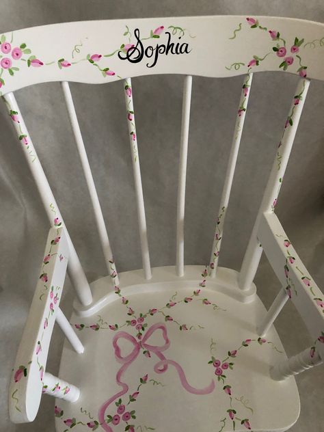 "beautiful rocking chair, painted with vines of flowers and a pink bow. May be personalized at no additional charge. Please add child's name in \"notes area when ordering. size: 29\"h x 20'W X 22\"d" Painted High Chairs, Pink Rocking Chair, Painted Kids Chairs, Childrens Step Stool, Rocking Chair Makeover, Painted Rocking Chairs, Kids Rocker, Baby Rocking Chair, Kids Desks