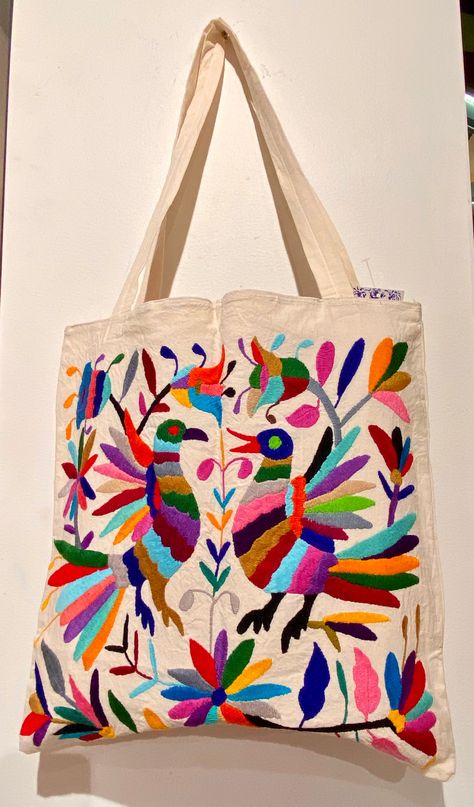 Gorgeous and bright totes, hand-embroidered with whimsical animals by artisans in Tenango de Doria, Hidalgo, Mexico. This spacious bag makes it easy to transport items for work, home, or travel. Handcrafted with care, each piece features vibrant colors and intricate details. Tote measures 15'' x 15'' Sicilian Kitchen, Hand Painted Tops, Mexican Bags, Mexican Embroidery Designs, Mexican Things, Mexican Top, Mexican Bag, Make A Shirt, Mexican Gifts