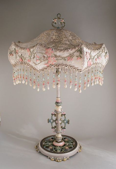 Antique large scale table lamp with flowers has been hand painted and holds an Ivory Carousel silk lampshade. The shade is covered in a luxurious Edwardian era ivory silk satin with silver woven through it. This was from an antique wedding gown and is overlaid around the edge with antique embroidery in pinks and greens. This a a romantic, feminine lamp and lights up beautifully. A jeweled pull chain turns the lamp on and off. Overall height is 32 inches to the top of the finial. The shade is 21 Feminine Lamp, Fancy Lamp, Antique Furniture Victorian, Victorian Shabby Chic, Chandelier Diy, Shabby Chic Table Lamps, Antique Table Lamps, Shabby Chic Lamp Shades, Antique Lamp Shades