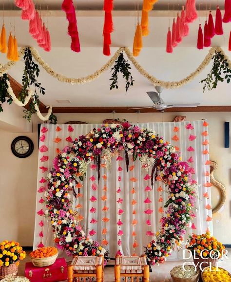 Traditional Indian Decor with tassels and flowers. Ring Backdrop with tassel strings on the ceiling. Contact us for further details.

#tassels#flowers#ring#backdrop#mehendidecor#traditionaldecor#weddingdecor#indianweddingdecor#thedecorcycle Ring Backdrop Ideas, Ganpati Ring Decoration, Flower Ring Backdrop, Indian Gender Reveal Ideas, Ring Backdrop Decoration Ideas, Ring Ceremony Decoration Indian, Rice Ceremony Decoration Indian, Traditional Baby Shower Indian, Mehandi Decorations At Home