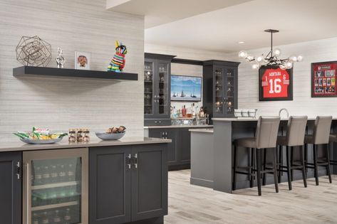 Dark Gray Basement Bar and Entertainment Area. Sharon L Sherrman, Thyme & Place Design Man Cave Flooring, Sports Theme Basement, Transitional Basement, Gray Basement, Custom Light Fixtures, High Top Tables, Basement Kitchen, Diy Furniture Renovation, Best Flooring