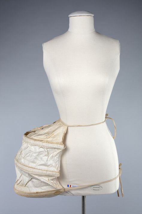 Hand-sewn pannier panel to be worn on one side of hip under a skirt to provide shape. Semi-circular hoops with stiff boning. The name "Hollyday" is written in pencil on the bottom edge. Traditionally, two panniers would be worn, one on each hip. Pannier Skirt, Hoop Skirt Boning, 1700s Pannier Dresses, Rococo Pannier, Inner Corset Construction, Edwardian Bustle Pad, Hip Pads, Rococo Fashion, Collection Ideas