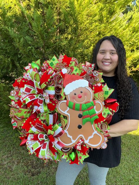 This charming Gingerbread Wreath is a delightful addition to your holiday decor. Each wreath is custom made to order, ensuring a unique and personal touch for your home. Adorned with festive mesh, ribbons, and bows, this wreath is further enhanced with a whimsical gingerbread sign that adds a touch of sweetness to any space. ‼️ Please note that ribbon patterns and colors may vary, but rest assured each wreath is crafted with care to capture the cozy spirit of the season.   🎀MADE TO ORDER🎀 I al Gingerbread Christmas Wreaths, Gingerbread Mesh Wreath, Whimsical Christmas Wreath, Gingerbread Wreaths Christmas, Gingerbread Decorations Diy, Gingerbreadman Wreath, Candy Christmas Wreath, Santa Clause Wreaths, Holiday Door Decorations For Work