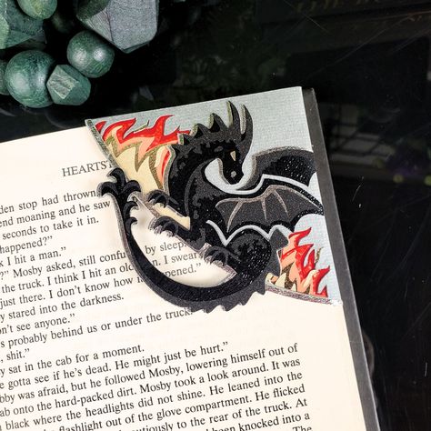 Introducing our Black Dragon Paper Corner Bookmark, a must-have for book lovers and fantasy enthusiasts. The intricate black dragon design, crafted with sparkling flames, will transport you to a world of magic and wonder every time you read. Elevate your reading experience with this luxurious and exclusive bookmark. Made with a combination of printed and textured cardstock and gold metallic vinyl for added shine. *Please note - due to the spacing on this design, we cannot add a name to this book Bookmark Corner Ideas, Diy Dragon Bookmark, Book Mark Holder, Book Mark Handmade, Mens Bookmark, Cool Bookmark Ideas, Felt Bookmarks Diy, Fancy Bookmarks, Diy Book Marks