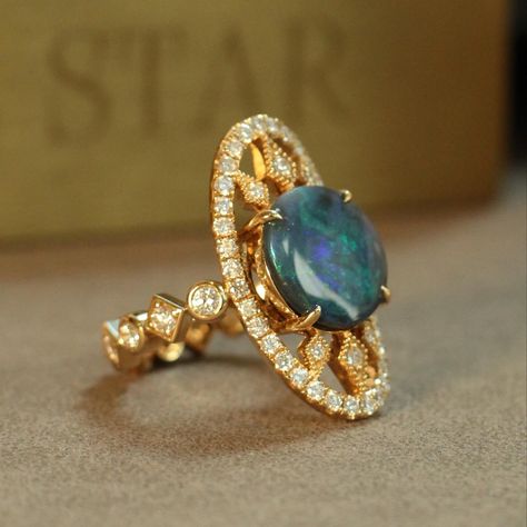 It’s bold, it’s got that architect vibe, and it’s just dripping with elegance 🪐 This piece centers around an Australian black opal, known for its rich, oceanic color play, set in a shield-shaped gold frame that adds a touch of drama. The opal is the star here, but the supporting cast isn’t shy either—small diamonds are sprinkled across the band, giving that extra sparkle. It’s all tied together on a gold band that’s got a bit of heft, balancing the opal’s natural beauty with a sturdy, luxe f... Star Jewellery, Australian Black Opal, Color Play, Star Jewelry, Play Set, Black Opal, Gold Band, Gold Bands, Gold Frame