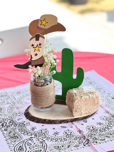 Used round wood a mason jar some tule and painted the cactus from the dollar tree and added the small bailes from the dolllar tree. The wood cut images came from hobbylobby. Mason Jar Western Centerpieces, Western Style Centerpieces, Cow Mason Jar Centerpieces, 1st Rodeo Centerpieces, First Rodeo Centerpiece, Cowboy Centerpiece Ideas, Baby Shower Dollar Tree, Western Table Decor, Cowboy Centerpieces