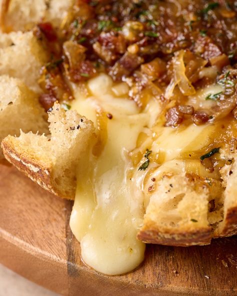 This Caramelized Baked Brie Bread Bowl is sure to be a huge hit at your holiday party! Crunchy bread... gooey brie cheese... and bacon onion jam... what's not to love. A must-make for cheese lovers! Garlic Prosciutto And Hot Honey Baked Brie Bread Bowl, Bruschetta Baked Brie, Brie Stuffed Sourdough, Baked Brie In Sourdough Bread Bowl, Bree Cheese Appetizer, Bacon Cheese Ring With Jam, Fancy Food Ideas, Baked Brie In Bread Bowl, Baked Brie Bread Bowl