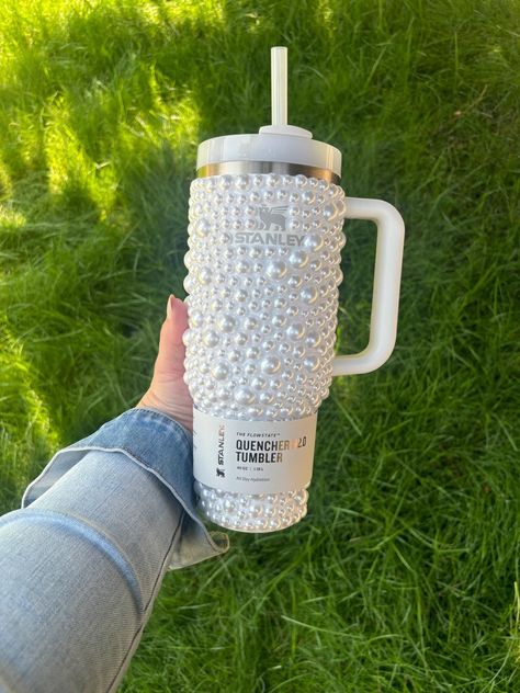 DESCRIPTION: This is for the purchase of 1, 40oz, 30oz or 20oz  Stanley quencher with hand laid pearls as shown. Please note that the logo on this cup is not covered in crystals. If you would like your cup to have the logo covered in crystals it is an extra charge. Please contact us with your color preference for the logo and for a quote to have the logo covered.  BASE CUP: Example photo is shown with a 40oz cup. Please note that the 20oz option does not come with a handle. We offer sizes 20,30 Custom Stanley Cup, Bedazzled Stanley Cup, Cute Stanley’s, Cute Stanley Cups, Stanley Decor, Stanley Cup Designs, Stanley Cup 40 Oz, Stanley Products, Trendy Water Bottles