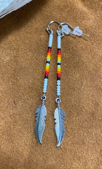 These are beaded with white, black, red, orange, and yellow colored seed beads. Native American Beading Patterns, Simple Beaded Earrings, Simple Bead Earrings, Seed Bead Jewelry Patterns, Trinket Jewelry, Beaded Earrings Native, Stick Earrings, Beaded Earrings Diy, Native American Beaded Earrings