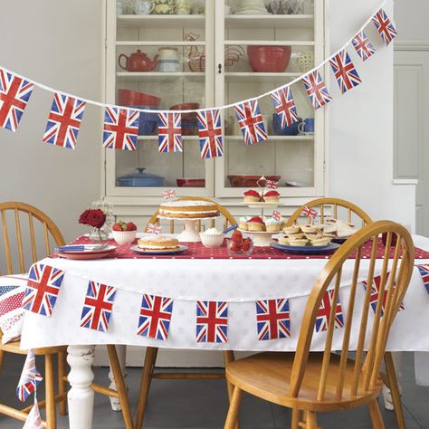 Table and chairs decorated with Union Jack bunting, with backdrop of white armoire. England Football Party, Lunch Party Ideas, Royal Picnic, Coronation Party Ideas, British Picnic, Harry Meghan Wedding, Paddington Party, Royal Jubilee, Jubilee Cake