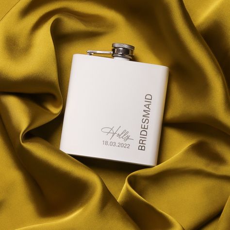 A white 6oz stainless steel hip flask, featuring elegant engraving for the bridal party. The compact size makes it perfect for discreet sipping on-the-go and the stylish design is sure to delight the members of the bride's entourage . This engraved hip flask is crafted from anodised stainless steel, and features a curved front. . This Personalised 6oz Glass White Hip Flask comes with optional Black Gift box and Funnel, just select your preference from the drop down menu Product Info Material: Stainless steel Dimensions: H9.5cm x W9.2 x D2cm Capacity: 6oz